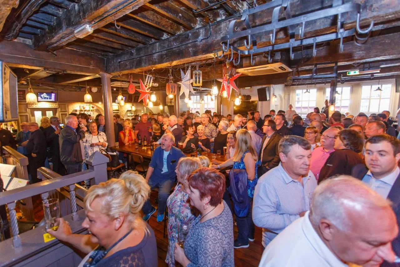 a large crowd of people standing around a bar at Fenwick Sunrise Hotel in Liverpool